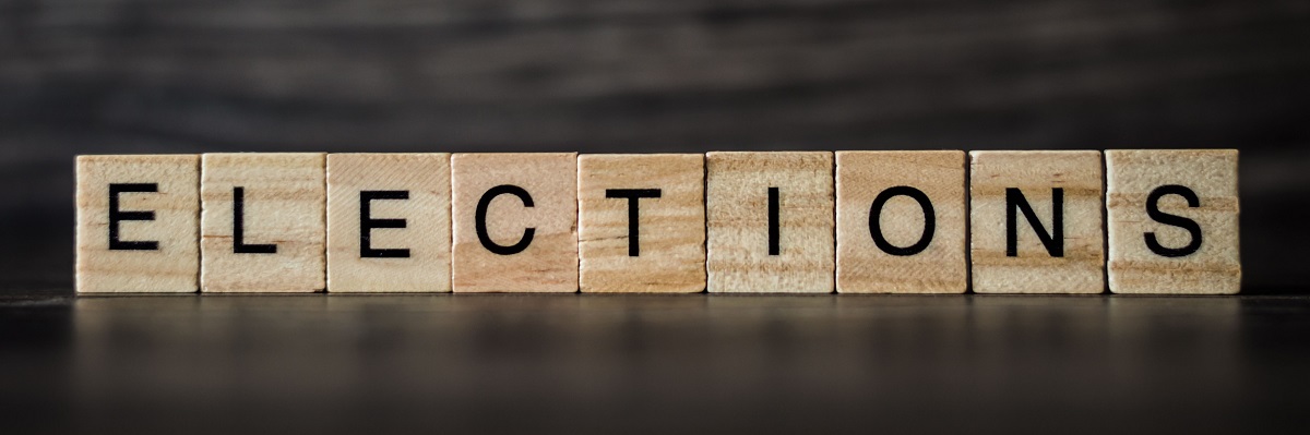 das Wort Wahlen, bestehend aus hellen quadratischen Holztafeln auf dunklem Holzhintergrund